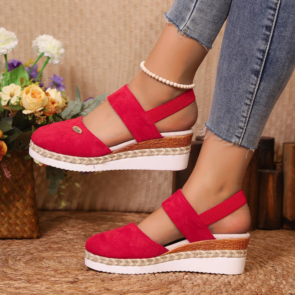 Red closed-toe slingback wedges with a fabric upper, elastic back strap and rope-trimmed wedge sole, worn with jeans